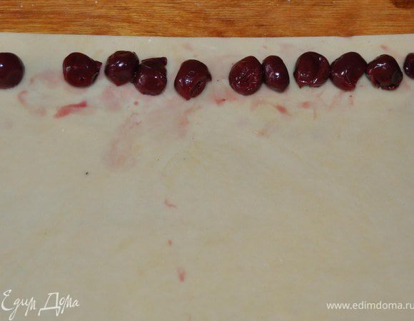 3.	Каждую часть раскатать в длинный прямоугольник шириной 5-6 см, по середине выложить  вишню. скатать трубочку.