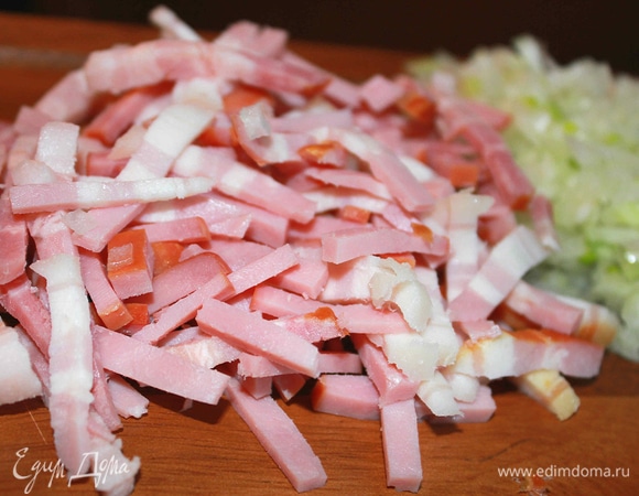 Бекон нарезать небольшими кусочками. Лук очистить и измельчить.
