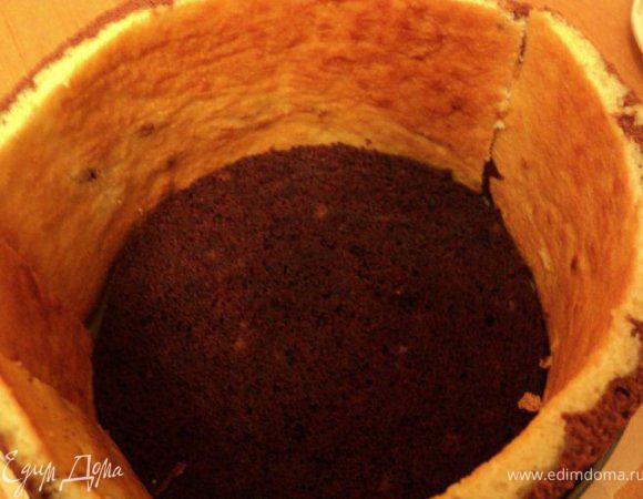 Дно разъемной формы застелить бумагой для выпечки, по бокам установить пласты сигаретного бисквита, на дно положить пласт шоколадного бисквита.