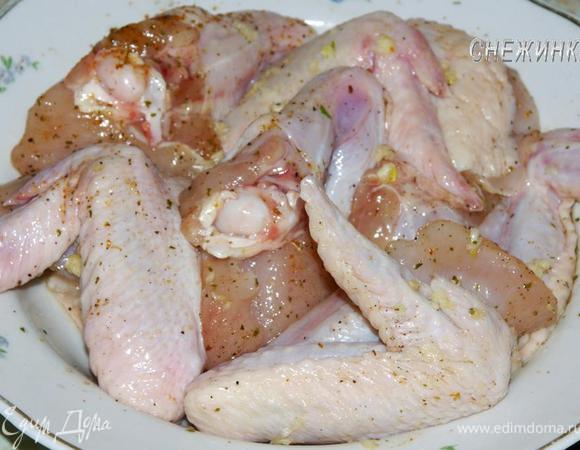 Куриные крылышки помыть, обсушить. Солим, перчим, немного посыпаем приправами, обмазываем чесноком, выдавленным через пресс.