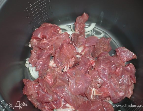 Помыть говядину в холодной воде, обсушить, нарезать кусочками. Кастрюльку мультиварки смазать раст. маслом, уложить нарезанный полукольцами лук и мясо