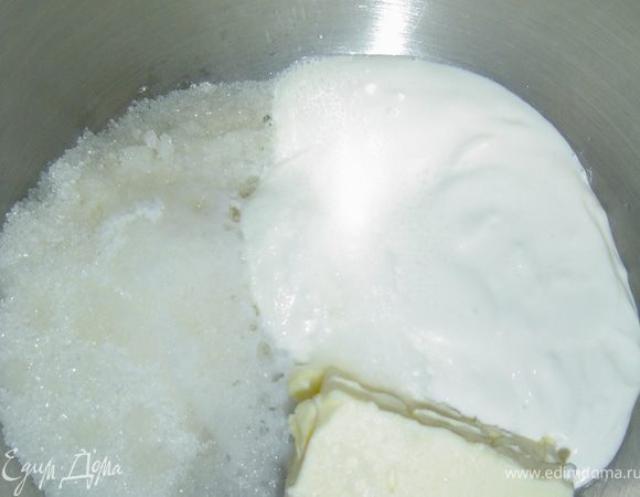  Начинаем процесс приготовления с того, что высыпаем замороженную вишню(без косточек) в кастрюлю и засыпаем сахаром, даем постоять минут 15, а когда появится жидкость ставим на медленный огонь и варим, периодически помешивая, 15 минут.
 Пока вишня уваривается готовим тесто. К размягченному маслу добавляем сметану,сахар,гашеную уксусом соду, перемешиваем и по немного добавляем муку, ее нужно добавить столько, чтобы тесто получилось эластичным и тугим. У меня ушло около 2 стаканов.