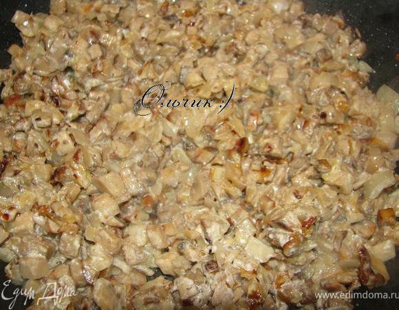В середине жарки, когда грибы выделили жидкость, солим, перчим. Жарим до готовности. Жидкость должна полностью выпариться. Добавляем лук с чесноком, сметану и пропариваем еще пару минут.