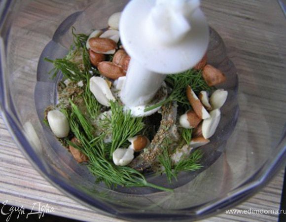 Зелень помыть, обсушить. У мяты и кориандра оборвать листики, сложить в чашу блендера, добавить лук, арахис, хлеб, пряности.