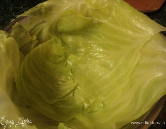 Взбить вилкой яйцо с 1 ст.ложкой сметаны. Взять конусообразную миску, смазать ее слегка маслом и выстелить листьями капусты, свесив края по бокам ( для того, что бы закрыть фаршированную капусту). Листья в местах наложения друг на друга смазать яйцом со сметаной.