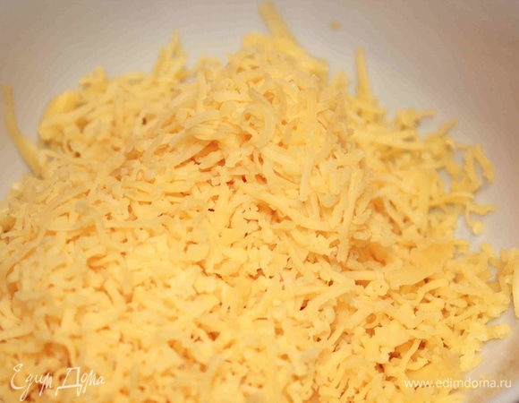 Делаем сливочную начинку. Сыр натереть на мелкой или средней тёрке. Добавить сливки и яйца. Перемешать.