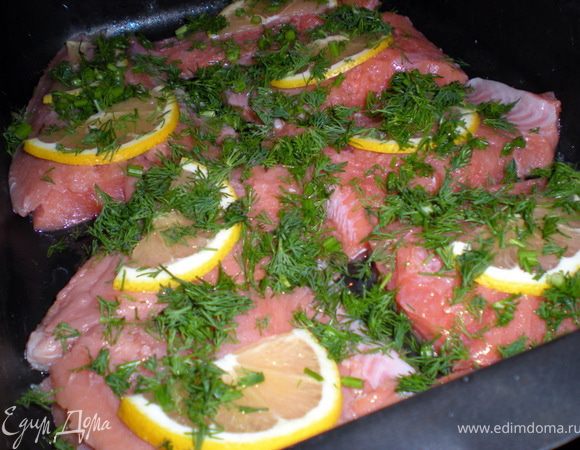 Нарезать на порционные кусочки.На каждый кусочек положить по ломтику лимона,присыпать зеленью,посолить,поперчить.
