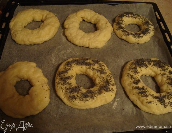 Выложить сформированные бублики на застеленный пергаментом и слегка присыпанный мукой противень, накрыть полотенцем и дать расстояться 1,5-2ч. Далее самое простое, но никак не фотографируемое. Вскипятить в большой кастрюле 2 л воды, добавить сахар для обварки, убавить огонь. Осторожно растянуть бублик и опустить на 30-40 сек. в кипяток, один раз перевернув. Достать бублик шумовкой, воду стряхнуть и положить опять на противень. Посыпать бублики маком.
