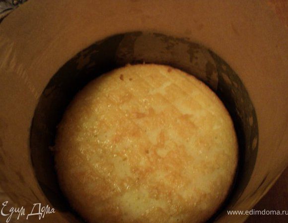 Бока разъемной формы обернуть бумагой для выпечки, на дно положить бисквит. Кисточкой смазать сиропом для пропитки.