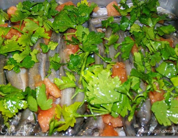 Смешаем вместе лимонный сок, бальзамический уксус, давленный чеснок, сахар, соль, прованские травы и оливковое масло. Польем этой смесью мойву. Сверху посыпем рубленной петрушкой