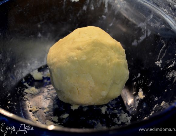 Сбрызнуть смесь 2 стол.ложками воды,перемешать вилкой.Скатать из теста шар,разделить пополам.