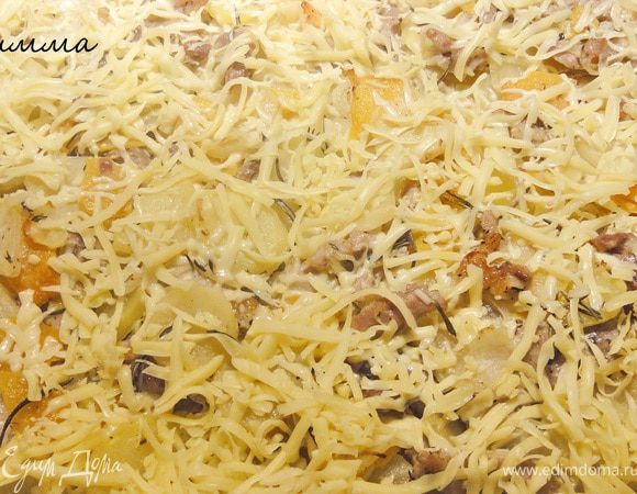 Выпекать при температуре 190 гр. Через 30 минут дольки чеснока убрать и распределить тертый сыр. Отправить в духовку еще на 10 минут.