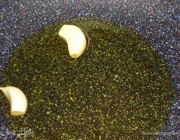 Разогреть оливковое масло с чесноком, его лучше раздавить ножом.