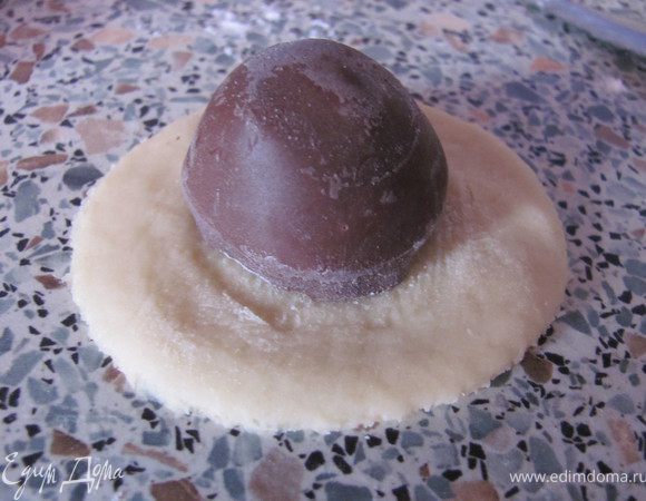 Достав из холодильника тесто, раскатать его и вырезать стаканом кружочки. На него положить конфетку.