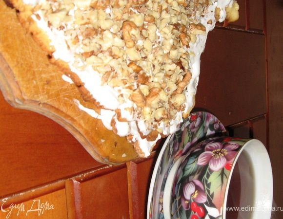 После остывания коржей, смазываем их обильно кремом. Сверху посыпаем измельченными скалкой орехами. Разрезаем на 8 частей и ставим в холодильник. Через несколько часов получаем вкусные пирожные к чаю или кофе.