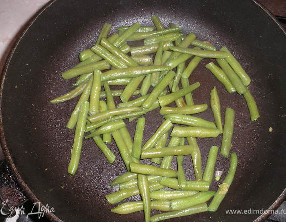 Стручковую фасоль отвариваем несколько минут до хрустящего состояния. Отжимаем и поджариваем 2–3 минуты в сковороде, где жарился картофель.