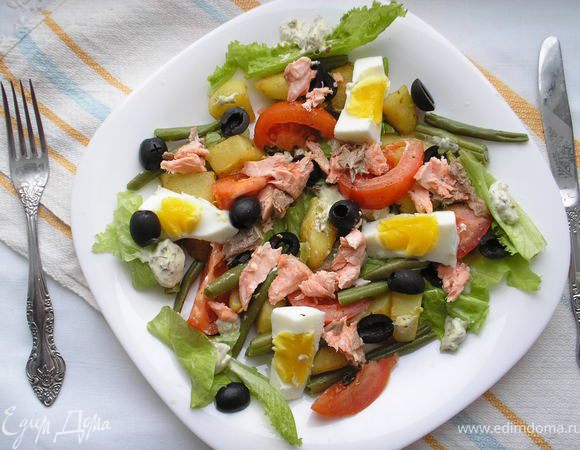 Начинаем сборку салата: выкладываем салатные листья, на них немного соуса, потом картофель, стручковую фасоль, помидоры, оливки, яйца. Лосось руками рвем на средней величины куски и выкладваем сверху на салат. По-немногу выкладваем соус произвольно по салату. Немедленно подаем!