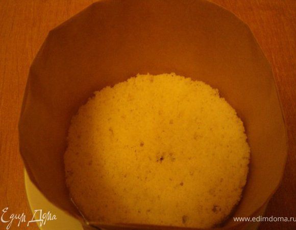 Так как у меня не было формы для выпечки нужного размера, я сделала кольцо диаметром 16см из нескольких слое бумаги для выпечки, остановив его плоскую тарелку. На дно положила пласт белого бисквита.