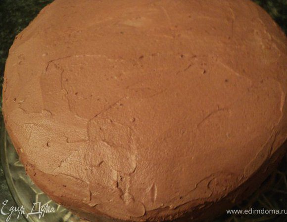Обмазать шоколадным масляным кремом нижнюю часть торта их шоколадного бисквита. Поставить обе части торта в холодильник на 2-3 часа.