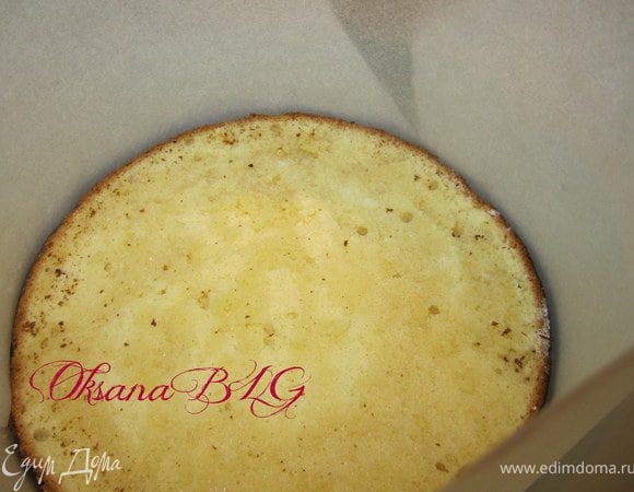 На дно разъемной формы положить корж (24 см). Бока формы можно поднять с помощью пергаментной бумаги.