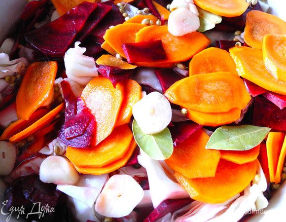 Пересыпать капусту морковью, свеклой, чесноком, кориандром и лавровым листом.