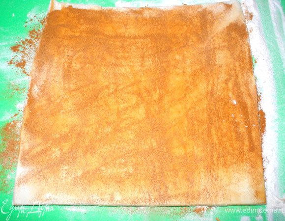 Посыпать немного муки на стол или подложку для раскатки теста. Взять лист слоеного теста 20Х20 см шириной 0,5 см (у меня оно было в рулете, я просто его разморозила).
Сверху хорошо посыпать молотой корицей.
