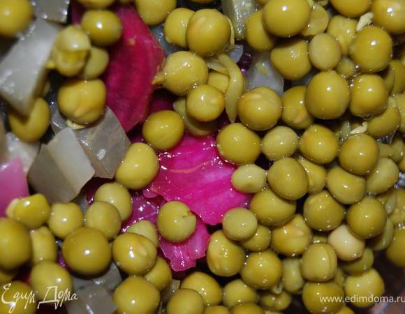 Добавим нарезанный соленый огурец и зеленый горошек.