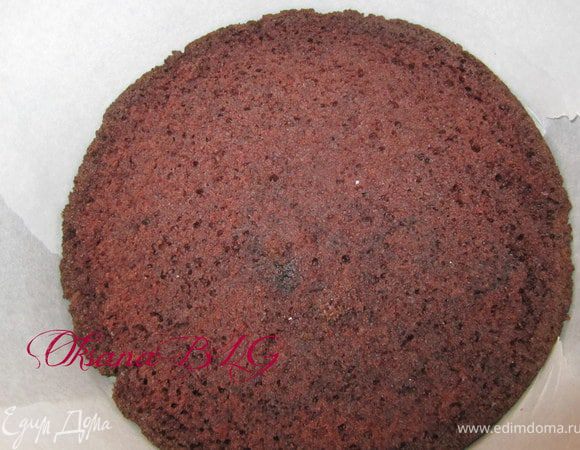 На дно разъемной формы положить один корж. Бока формы можно немного поднять с помощью пергаментной бумаги.