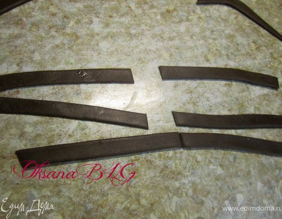 Украшения нужно готовить заранее, чтобы они подсохли. Шоко мастика раскатать и вырезать одинаковые полосочки.