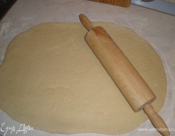 Тесто раскатываем в прямоугольник толщиной в 1 см. Смазываем его ратсопленным сливочным маслом и оставшимся сахаром. По желанию еще и какао. На тесто ровномерно выкладываем предварительно замоченный в кипятке и обсушенный изюм. Сварачиваем в рулет.