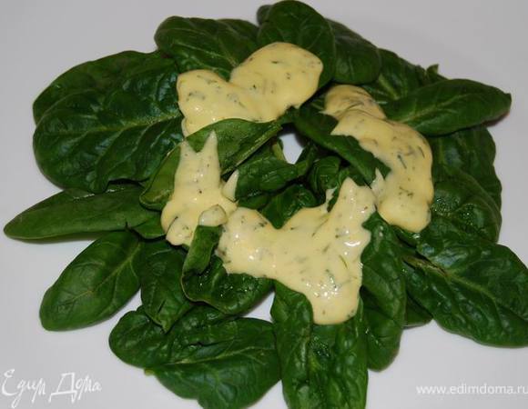 Выложим на тарелку листья шпината, сверху них, ближе к центру - немного заправки.