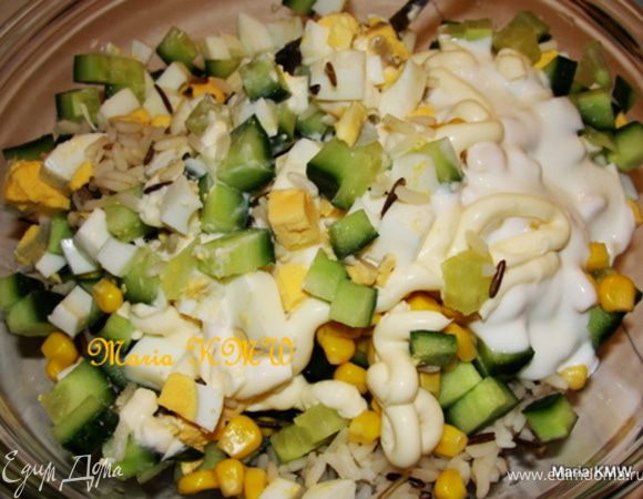 Порежем кубиками авокадо, огурец, яйца и прошутто. Смешаем все ингредиенты с рисом, кукурузой,  заправкой из йогурта и майонеза. Приправим солью, перцем. 