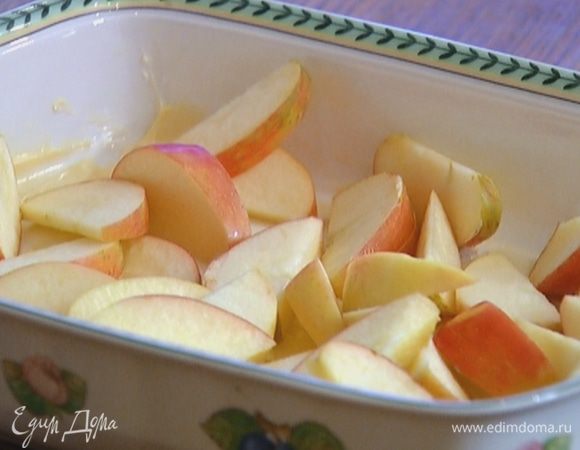Жаропрочную форму немного смазать сливочным маслом, выложить в один слой яблоки и посыпать их сахаром.