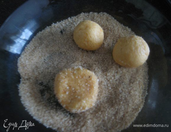 Чайной ложкой берем тесто, скатываем в руках быстро шарики, обмакиваем в сахар со специями и слегка приминаем. 