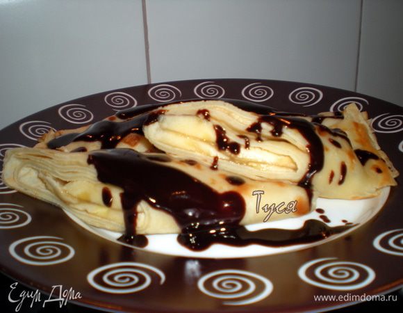 Подавать теплые блины полив шоколадом.