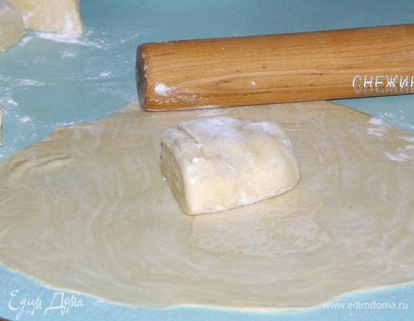 Духовку разогреваем до 230°C. Берем один кусочек теста и раскатываем круглой формы на посыпанной мукой поверхности, ориентируясь на размер Вашей формы для выпечки. Не забывайте постоянно посыпать поверхность мукой, чтобы тесто не прилипло и не порвалось.