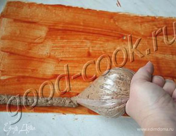 Тесто разморозилось и можно делать Сюрпризики. Пласт теста слегка смазать кисточкой на 2/3 высоты кетчупом, а на 1/3 - вбитым желтком (для склеивания теста). На "кетчуповый" край из целофанового мешка выложить "жгутиком" фарш.
(У меня фото этого шага не получилось, см. фото из оригинально рецепта http://www.good-cook.ru/tort/tort_455.shtml сайта Хорошая  кухня) 
