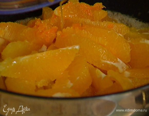 Разогреть в тяжелой, глубокой сковороде сливочное масло, добавить сахар и ванильный экстракт, выложить апельсины вместе с соком и цедрой.