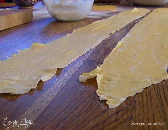 Отдохнувшее тесто выложить на рабочую поверхность, присыпанную мукой, и раскатать его в очень тонкий пласт (можно использовать машинку для раскатывания теста). 