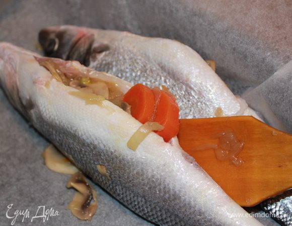 Положить овощи и грибы в рыбу. Сверху накрыть ломтиками апельсина. Положить веточку тимьяна.