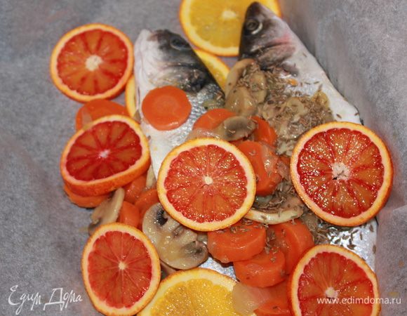 Сбрызнуть рыбу оливковым маслом. Положить на противень, застеленный бумагой для выпечки. Необходимо завернуть в бумагу нашу рыбку. Готовить в духовке, разогретой до 170°C в течение 20–25 минут.