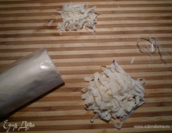 Фило тесто, не разворачивая сверток, нарезать тонкими срезами как показано на фотографии (свёрток теста из бумаги не вынимать, резать прямо с ней). Встряхните каждый "срез" пальцами (вот сейчас и удалите кусочки бумаги) и сложите ввиде медальонов на кандитерской бумаге.