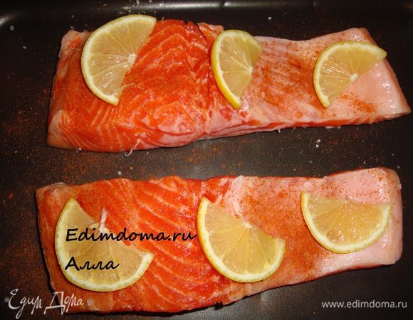 Лимон порезать тоненькими полукружочками и разложить по рыбе...