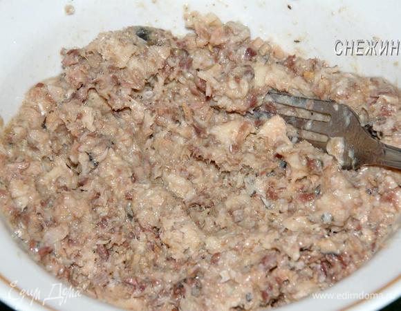 Пока тесто отлеживается в холодильнике, подготовим начинки. Консерву выложить в миску, размять вилкой вместе с жидкостью.