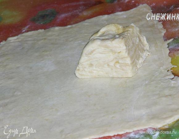 Берем один кусочек, раскатываем в виде прямоугольника, всё время притрушивая поверхность мукой.