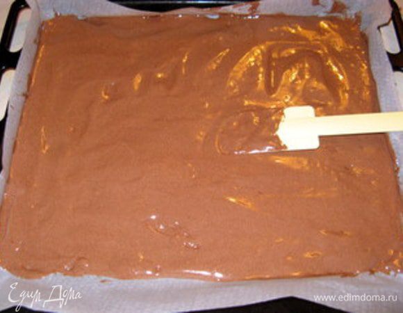 Противень накрыть пергаментом. Пергамент смазать сливочным маслом. Вылить в центр тесто и лопаткой растянуть до краёв противня. Слой теста должен быть равномерным и не утончаться к краям. Выпекать при 180° 10-12  минут. Готовый бисквит остудить и вырезать два коржа по величине разъёмной формы. Для данного количества ингредиентов форма не должна превышать 22 см в диаметре.