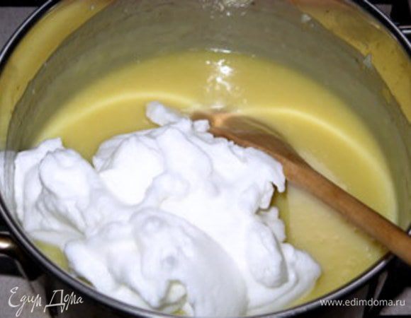 В другой кастрюльке довести сливки с сахарной пудрой до кипения. Вылить кипящие сливки на растаевший шоколад, перемешать и добавить сливочное масло комнатной температуры, порезанное на кусочки. Перемешать деревянной ложкой. Дать крему слегка остыть и ввести взбитый в пену белок.
