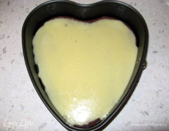 Разместить на дне разъёмной формы первый вырезанный корж. Сверху распределить половину крема.