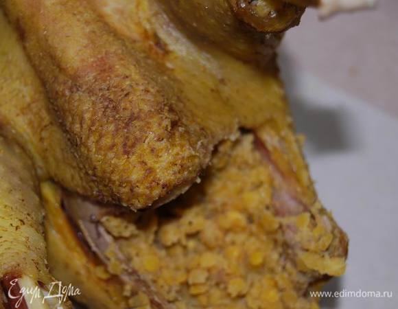 На столе разложим бумагу для выпечки таким образом,чтобы потом в нее можно было завернуть курицу. смажем ее размягченным сливочным маслом в тех местах,которые будут соприкасаться с курицей. Фаршируем курицу чечевицей.