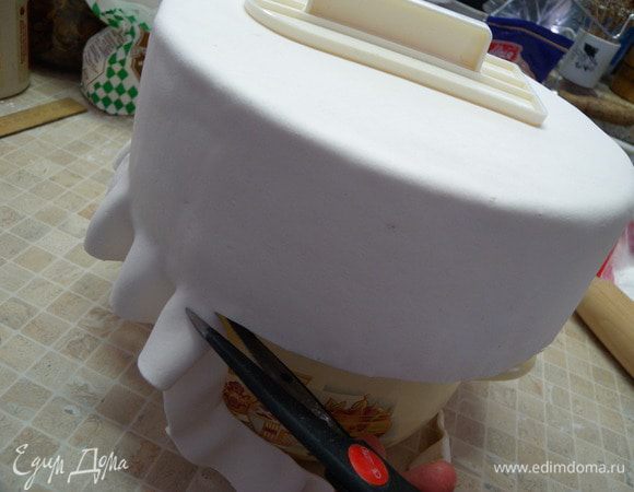 11. Нам станет видно, где закончился торт и из-за подставки лишняя мастика просто будет свисать. Срезаем  ее ножом скользя по металлическому дну от формы под бисквитом. (фото со второго торта). 